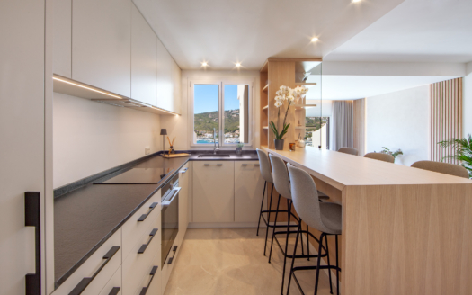 Una cocina moderna con una barra de desayuno y una ventana con vistas. Elegancia y funcionalidad en el hogar.